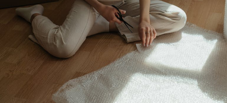 woman cutting bubble wrap.