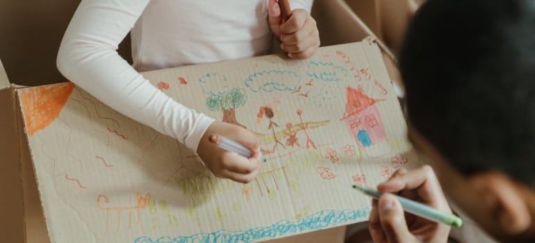 Picture of a child and adult playing with a box 