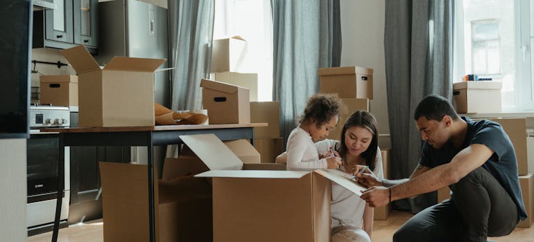 parents packing boxes with their daughter.