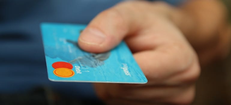 person paying for pool table movers Victoria BC residents recommend with a debit card.