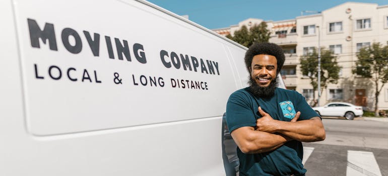 A man stands in front of a van, embodying the message, "What you need to know when hiring senior movers in Victoria," highlighting the importance of choosing the right support for seniors in transition.