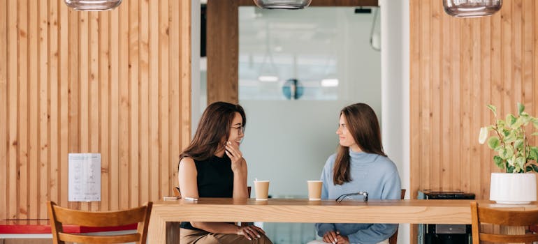 Woman discussing her move with her neighbor in a cafe.
