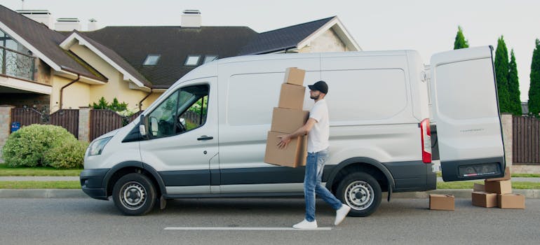 Man taking boxes out of a moving truck.