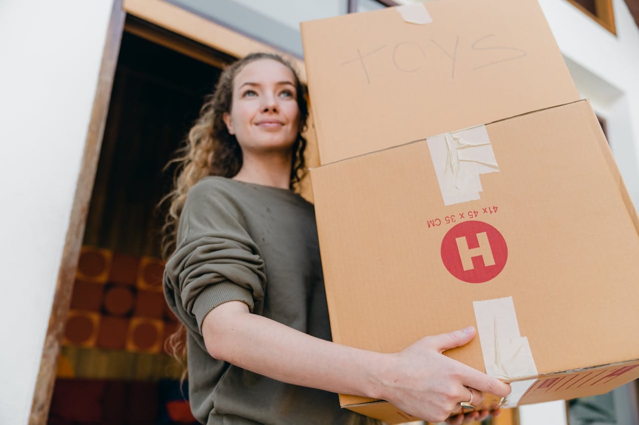 Woman carrying boxes and thinking about move out without disrupting your neighbors,
