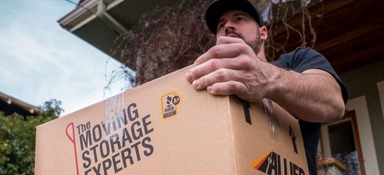 Hendra Moving and Storage employee carrying a box.