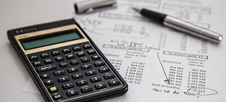 Calculator and pen on a piece of paper.