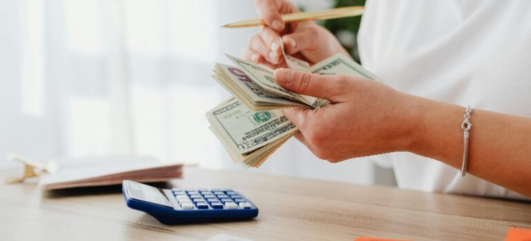 the best time to move is when you have enough financial resources, as the woman in the picture counting money