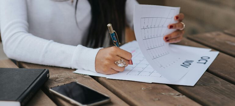 a woman writing in a calendar 