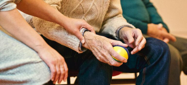 a healthcare professional holding a senior's hand
