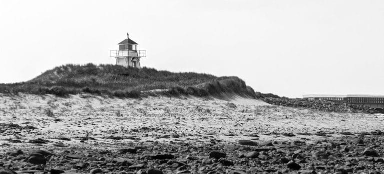 a lighthouse standing by the shore