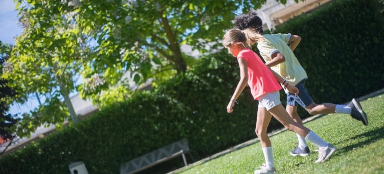 Kids Walking on the Grass Field