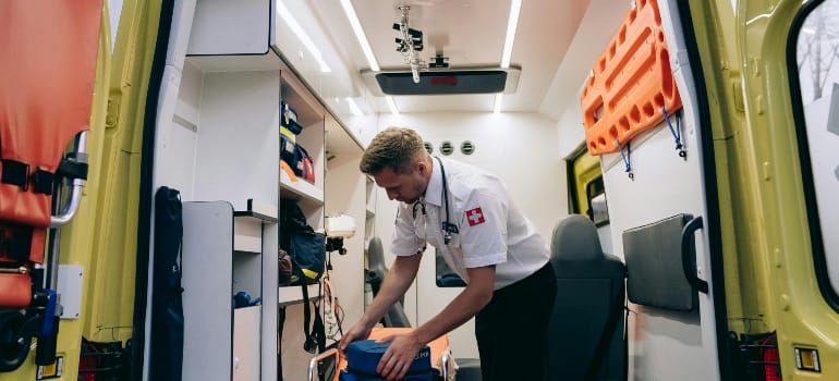 A Paramedic Holding Medical Equipment inside an Ambulance