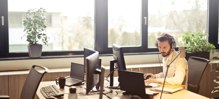 Man With Headphones Facing Computer Monitor