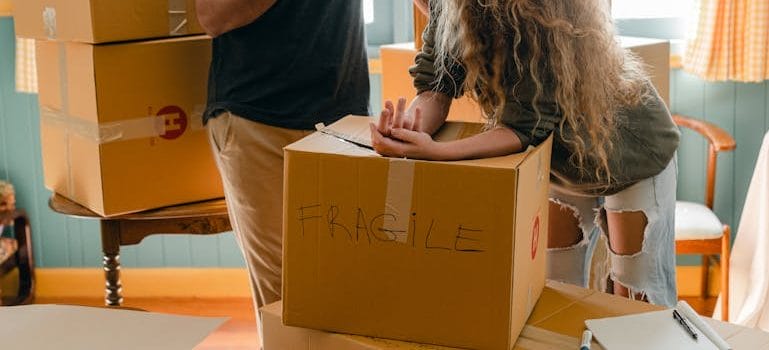 Woman and crop boyfriend near different boxes for moving