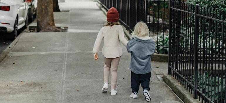 siblings walking on sidewalk