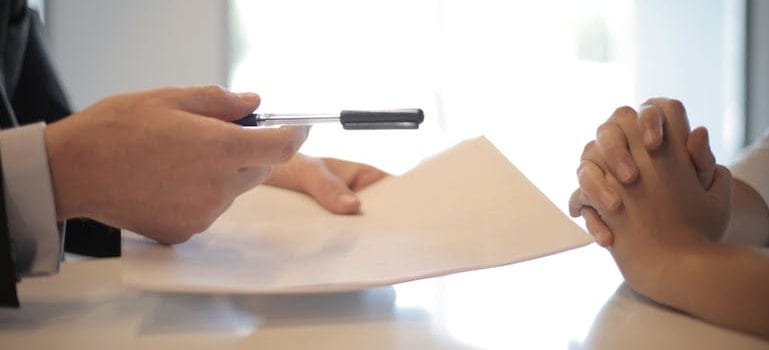businessman giving contract to woman to sign