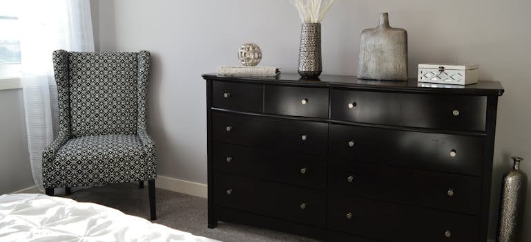 Gray and Black Chair Beside Black Wooden Lowboy Dresser