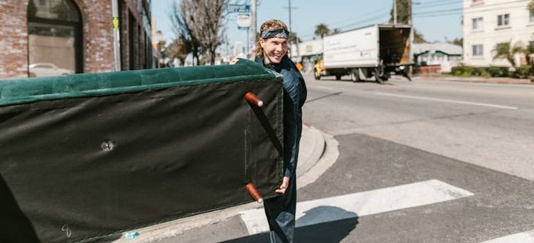 a man carrying a sofa