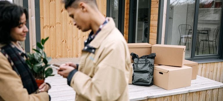 A Couple Standing Near the Carton Boxes