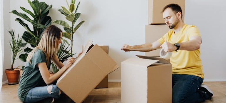couple sealing carton boxes during renovation