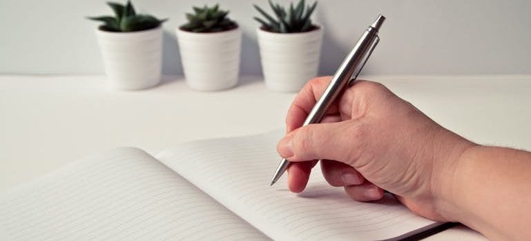 a person writing down When and How to Prepare for Moving Day