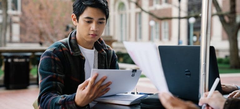 A Man in Plaid Long Sleeves Reading Papers