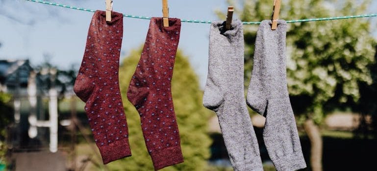 Multicolored socks drying on rope with clothespins in open air