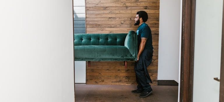 Man in Blue Denim Jeans Sitting on Green Sofa