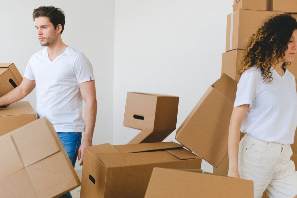 young couple carrying cardboard boxes
