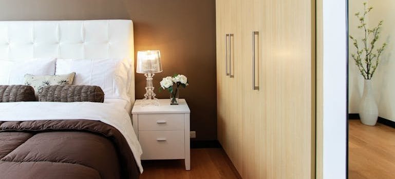 White Bed Next to White Accent Table