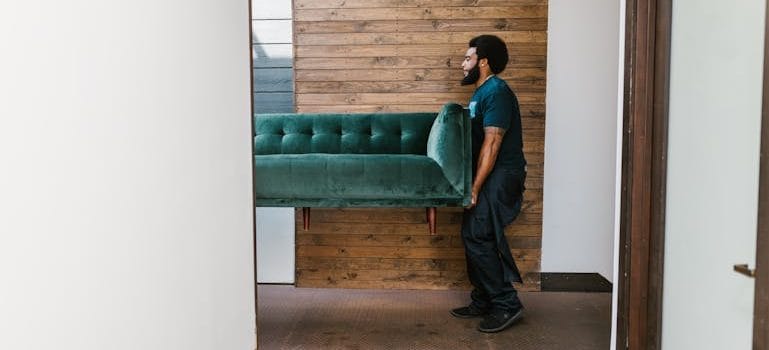 Man in Blue Denim Jeans Sitting on Green Sofa