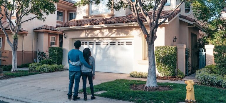 Couple Standing In Front of their House