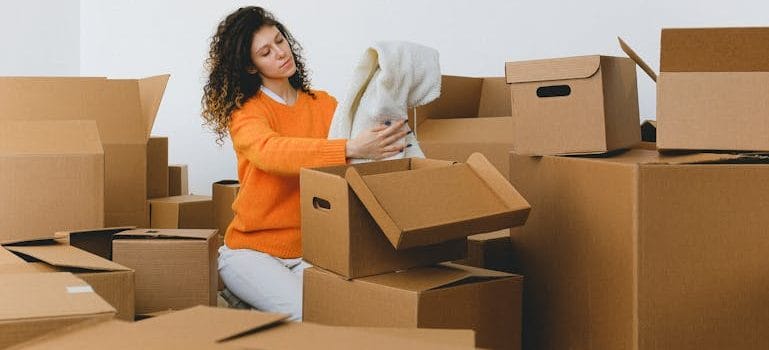 lady packing clothes into boxes during relocating