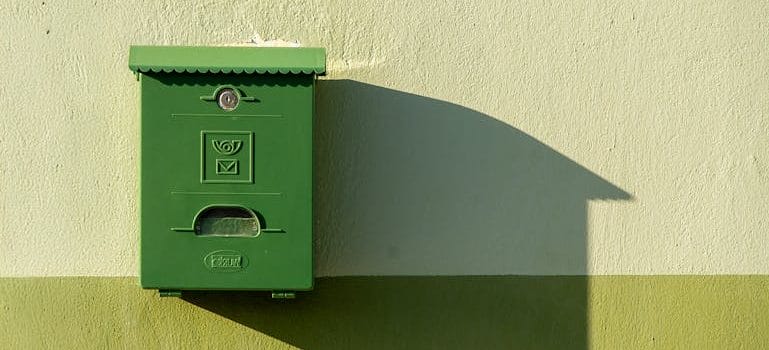 Green Postbox Casting Shadow on Wall