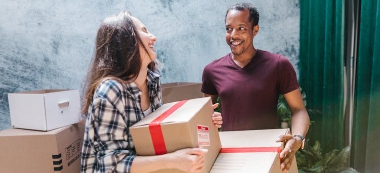 Man and Woman Carrying the Moving Boxes
