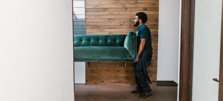 a man carrying a couch and thinking about The Cost of Moving to Nanaimo