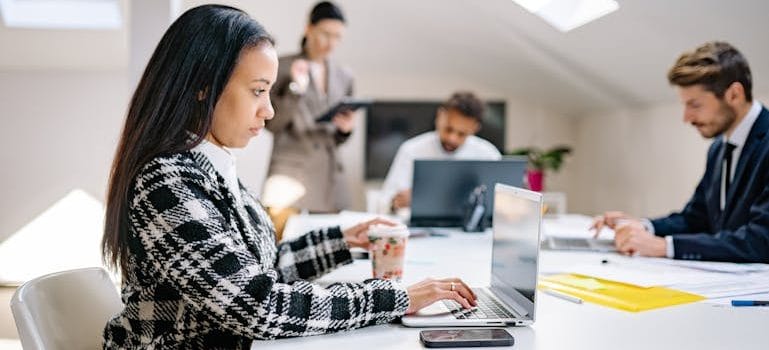 A Woman in Corporate Attire Using a Laptop at an Office