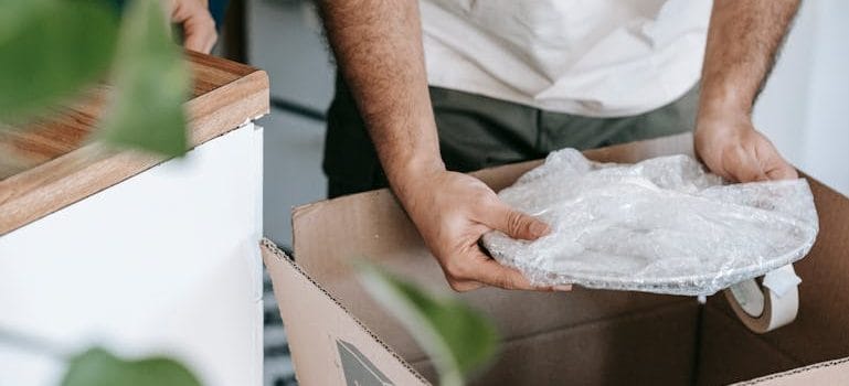 Man Putting A Wrapped Plate In The Box