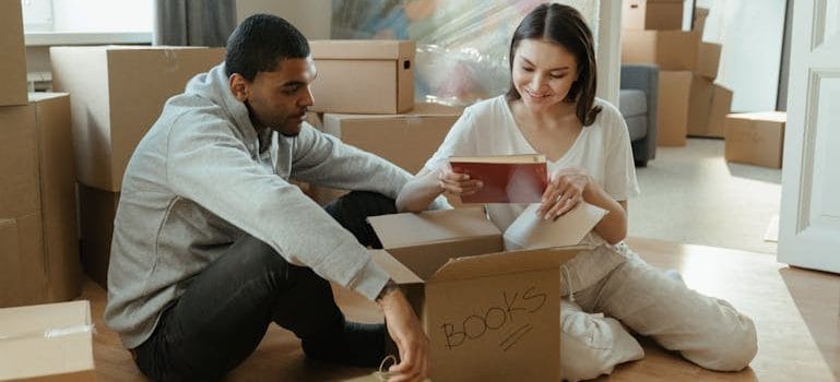 Man in Gray Dress Shirt Holding Brown Cardboard Box