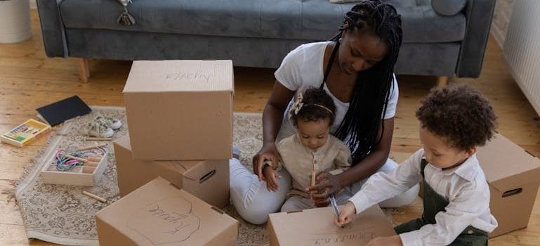 Little Boy Writing on Cardboard Boxes